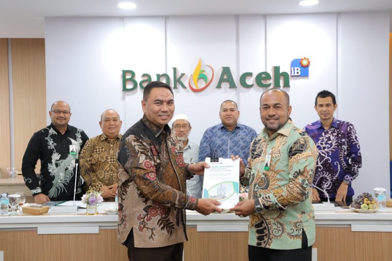 Direktur Utama Bank Aceh Fadhil Ilyas menerima Laporan Hasil Audit (LHA) opini Wajar Tanpa Pengecualian (WTP) atas laporan keuangan tahun buku 2025 dari perwakilan Kantor Akuntan Publik (KAP) Heliantono & Rekan di Gedung Action Center Bank Aceh, Banda Aceh, Jumat (13/1/2026). Foto: (Humas Bank Aceh)