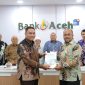 Direktur Utama Bank Aceh Fadhil Ilyas menerima Laporan Hasil Audit (LHA) opini Wajar Tanpa Pengecualian (WTP) atas laporan keuangan tahun buku 2025 dari perwakilan Kantor Akuntan Publik (KAP) Heliantono & Rekan di Gedung Action Center Bank Aceh, Banda Aceh, Jumat (13/1/2026). Foto: (Humas Bank Aceh)